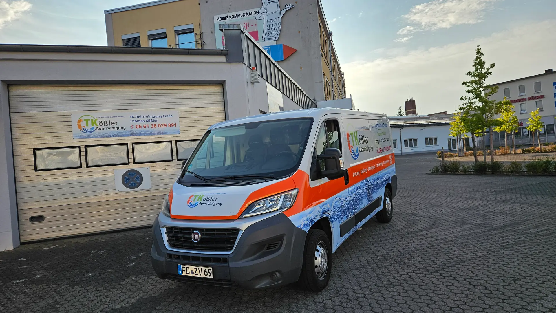 Firmenwagen der TK-Rohrreinigung Fulda mit Fuldaer Kennzeichen vor der eigenen Halle mit Firmenschild in der Rangstraße 39