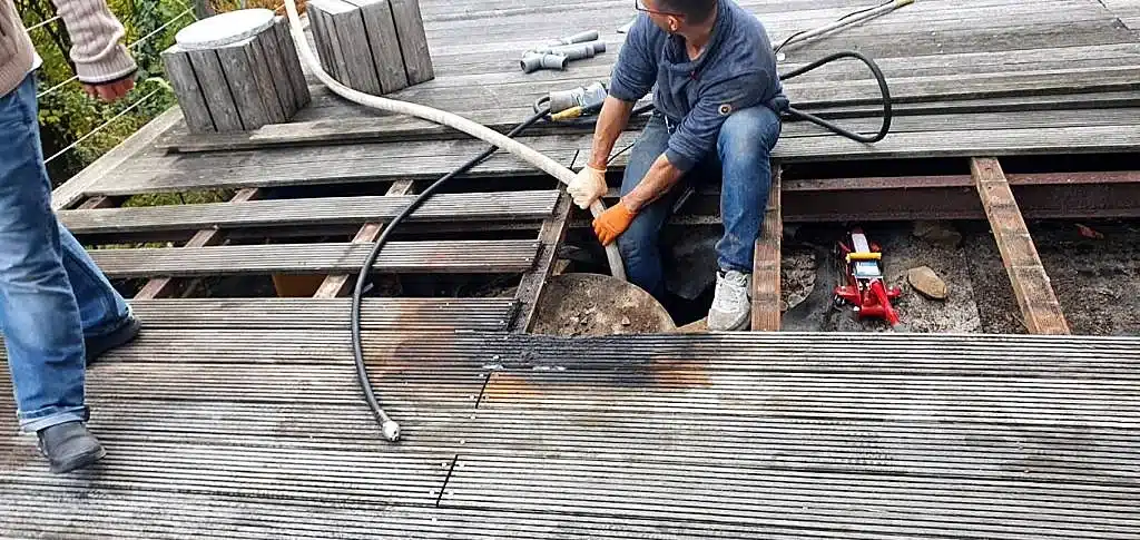Thomas Kößler bei Leitungsarbeiten unter einer Holzterrasse