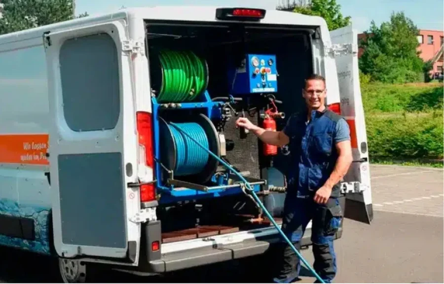 Mitarbeiter bei der Kanalreinigung an einem geöffneten Schacht