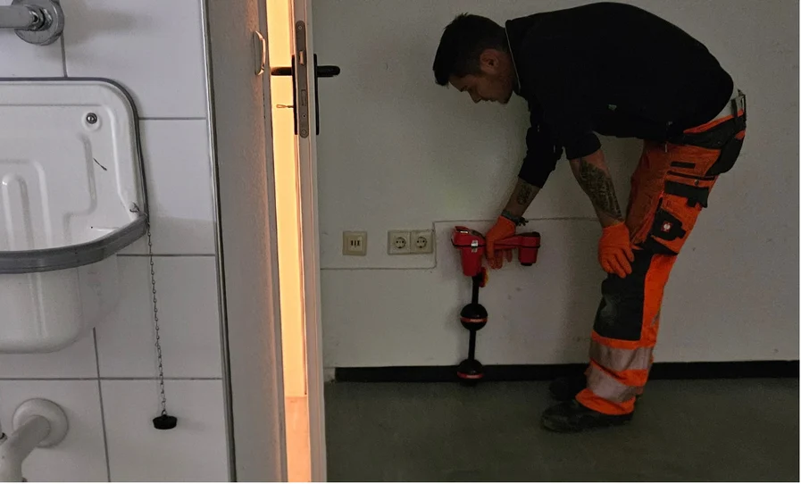 Mitarbeiter bei der Rohrortung einer Leitung im Gebäude
