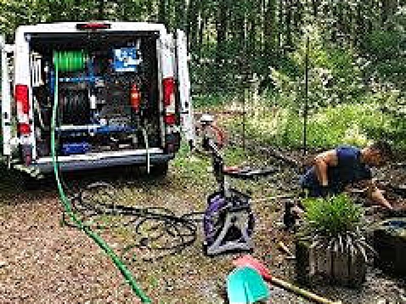Thomas Kößler bei einem Rohrreinigungs-Einsatz in Fulda mit Servicefahrzeug im Gartenbereich.